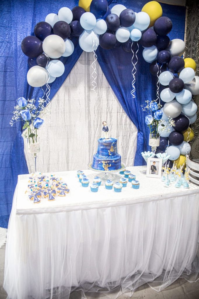 Montaje de comunión con arco de globos y tarta en el bar Cononda