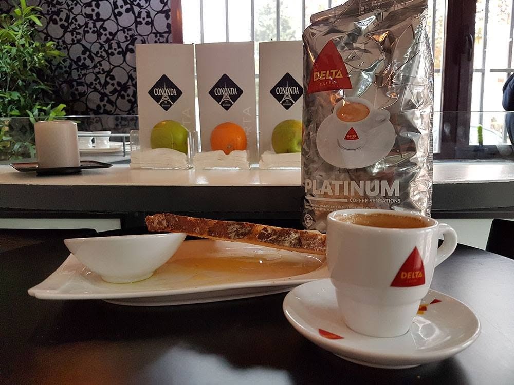 Taza de café y tostada con cartas de Cononda de fondo